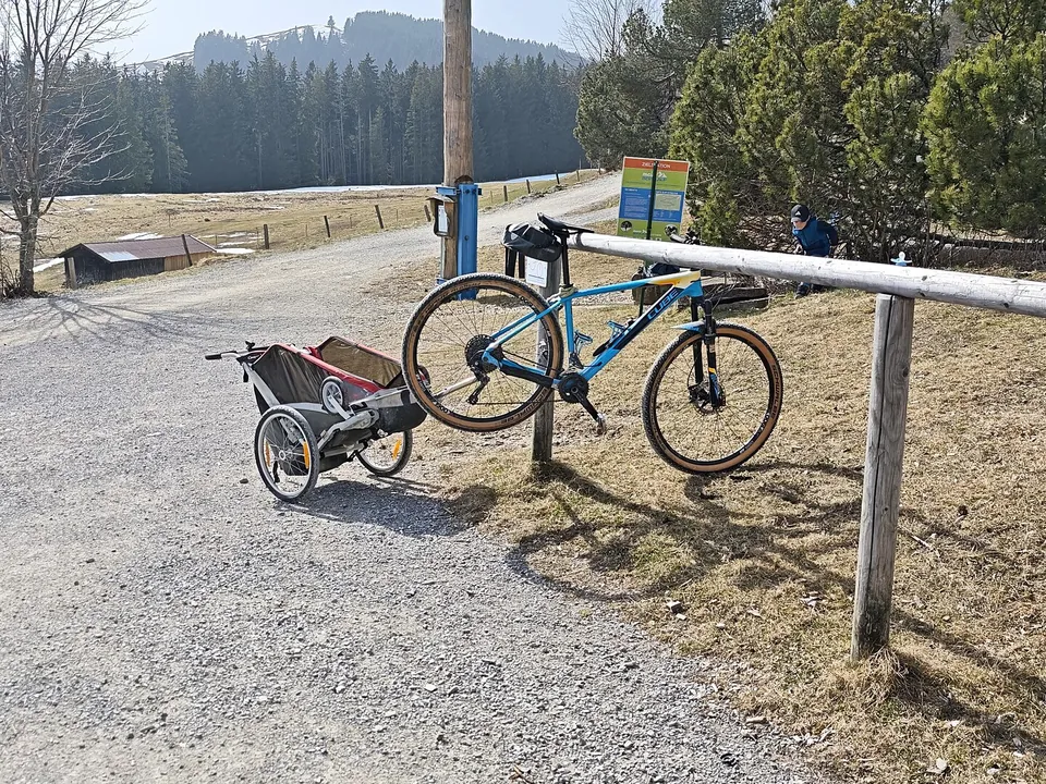 Mountainbike mit Kinderanhänger an einem Schotterweg in den Voralpen